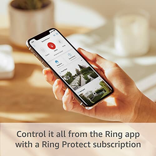 Hand holding a smartphone displaying the Ring app interface.